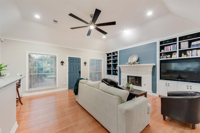 537 Estate Dr, Grand Prairie, TX 75052 - living area with vaulted ceiling, a ceiling fan, built in shelves, a glass covered fireplace, and recessed lighting