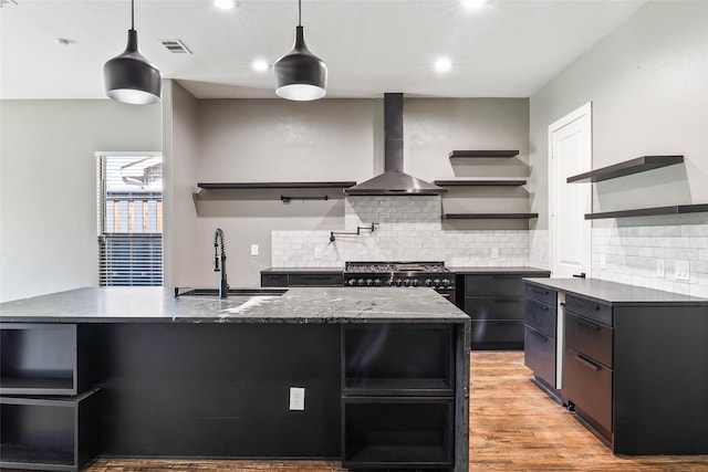 15321 Mount Evans Dr, Little Elm, TX 75068 - kitchen featuring open shelves, wall chimney range hood, tasteful backsplash, light wood-style floors, and hanging light fixtures