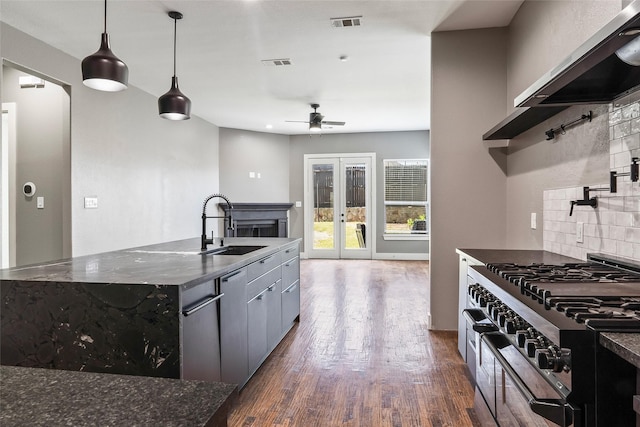 15321 Mount Evans Dr, Little Elm, TX 75068 - kitchen featuring appliances with stainless steel finishes, dark wood-type flooring, decorative backsplash, ceiling fan, and exhaust hood