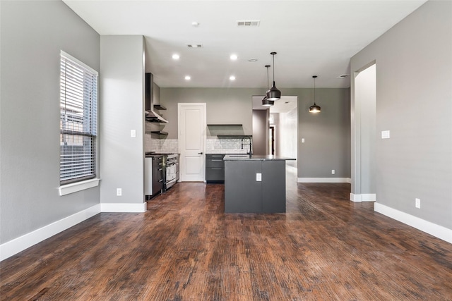 15321 Mount Evans Dr, Little Elm, TX 75068 - kitchen with high end stainless steel range oven, a kitchen island with sink, backsplash, pendant lighting, and dark wood-type flooring