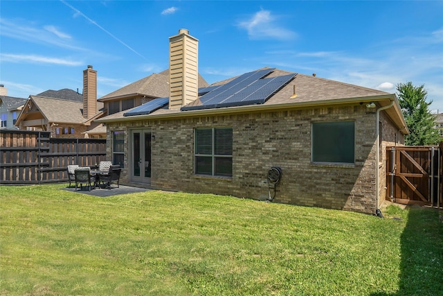 15321 Mount Evans Dr, Little Elm, TX 75068 - rear view of house with a fenced backyard, a patio, roof mounted solar panels, and a chimney