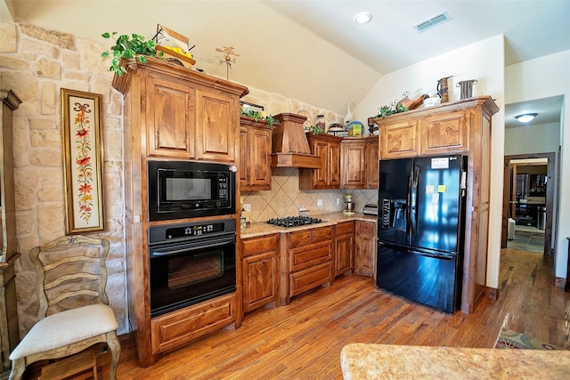 1702 High Point Dr, Pilot Point, TX 76258 - kitchen with black appliances, decorative backsplash, lofted ceiling, light wood-style flooring, and brown cabinetry