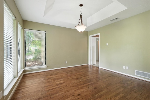 9901 Burnham Dr, Dallas, TX 75243 - empty room with wood finished floors and a raised ceiling