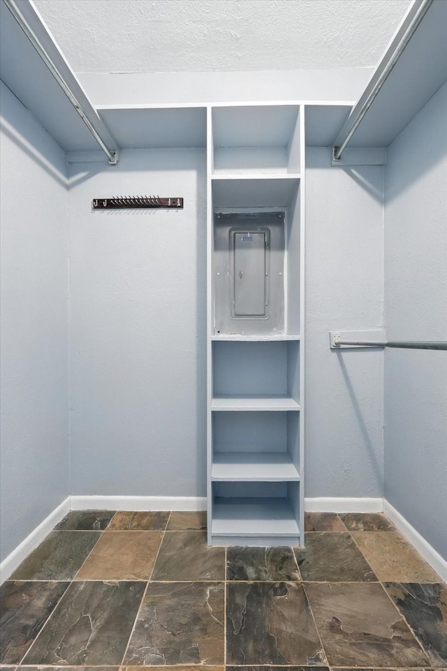 9901 Burnham Dr, Dallas, TX 75243 - spacious closet featuring electric panel and stone tile floors
