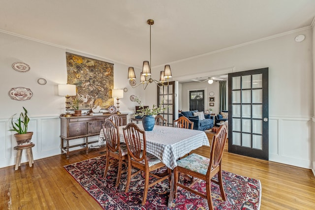 887 N Clinton St, Stephenville, TX 76401 - dining room with wood finished floors, a decorative wall, crown molding, wainscoting, and a chandelier