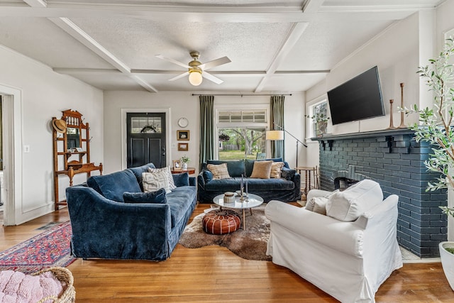 887 N Clinton St, Stephenville, TX 76401 - living area with coffered ceiling, wood finished floors, ceiling fan, a fireplace, and beam ceiling