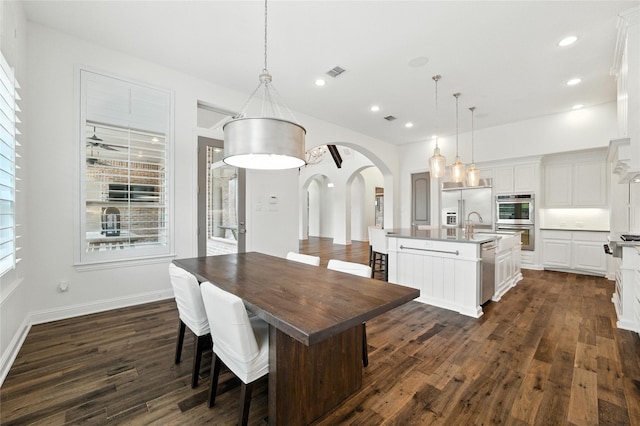 4510 Woodbine Ln, Prosper, TX 75078 - dining space featuring arched walkways, dark wood-style floors, and recessed lighting