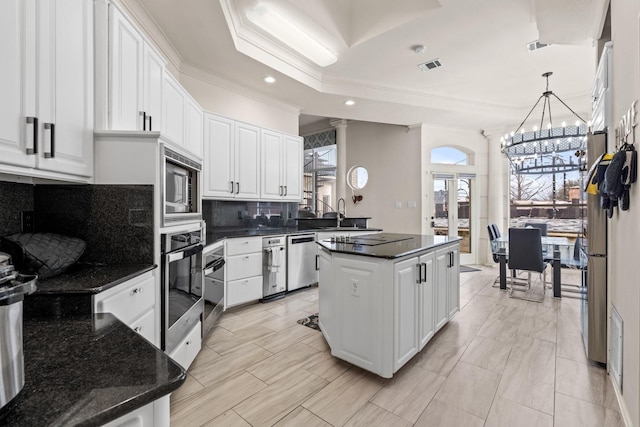 200 Mill Xing W Unit W, Colleyville, TX 76034 - kitchen featuring appliances with stainless steel finishes, decorative backsplash, white cabinetry, crown molding, and a chandelier