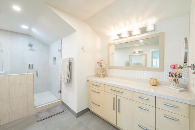 6956 Meadowbriar Ln, Dallas, TX 75230 - bathroom with vanity, vaulted ceiling, a shower stall, tile patterned flooring, and tasteful backsplash