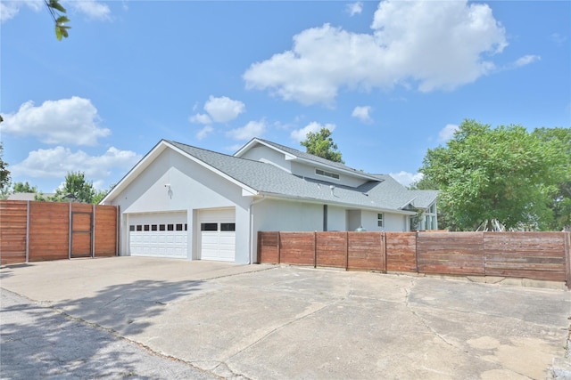 6956 Meadowbriar Ln, Dallas, TX 75230 - view of side of property with a garage, roof with shingles, driveway, and stucco siding