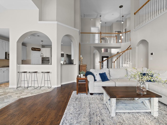 5503 Midnight Moon Dr, Frisco, TX 75036 - living area with a towering ceiling, wood finished floors, and stairs