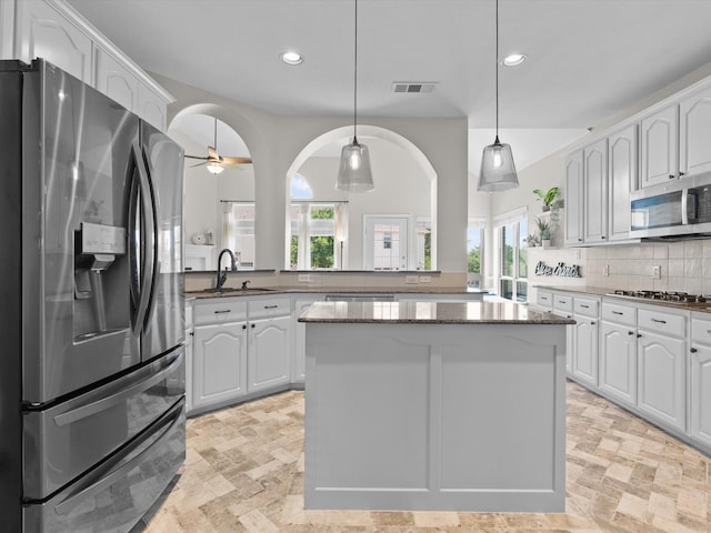5503 Midnight Moon Dr, Frisco, TX 75036 - kitchen featuring appliances with stainless steel finishes, stone tile floors, a center island, recessed lighting, and tasteful backsplash