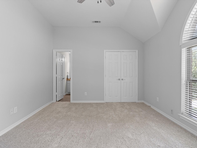 5503 Midnight Moon Dr, Frisco, TX 75036 - unfurnished bedroom featuring light carpet, vaulted ceiling, a closet, connected bathroom, and ceiling fan