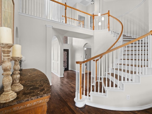 5503 Midnight Moon Dr, Frisco, TX 75036 - stairway featuring arched walkways, a high ceiling, and wood finished floors