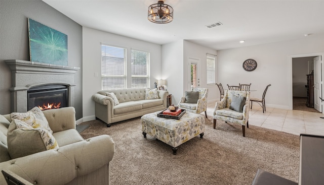 3814 Bastrop St, Melissa, TX 75454 - carpeted living area with a glass covered fireplace, tile patterned floors, and a chandelier