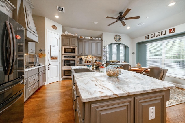 2604 Gavin Dr, Mansfield, TX 76063 - kitchen featuring appliances with stainless steel finishes, custom range hood, a center island with sink, ceiling fan, and plenty of natural light