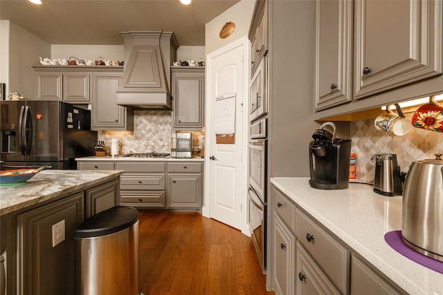 2604 Gavin Dr, Mansfield, TX 76063 - kitchen with stainless steel appliances, custom range hood, decorative backsplash, gray cabinetry, and recessed lighting