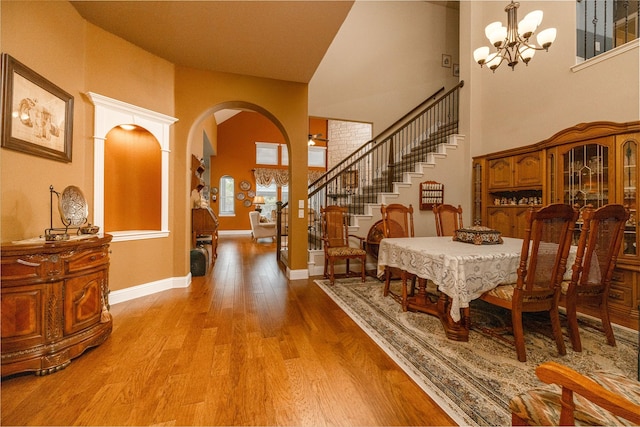 2604 Gavin Dr, Mansfield, TX 76063 - dining space featuring arched walkways, light wood-style flooring, a chandelier, stairway, and a high ceiling