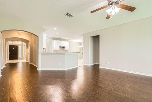 1119 Leafy Glade Rd, Forney, TX 75126 - unfurnished living room featuring dark wood-type flooring, a ceiling fan, arched walkways, recessed lighting, and a chandelier