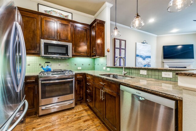 7333 Valley View Ln Unit 304, Dallas, TX 75240 - kitchen featuring appliances with stainless steel finishes, light stone countertops, light wood-type flooring, crown molding, and backsplash