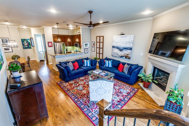 7333 Valley View Ln Unit 304, Dallas, TX 75240 - living area with ornamental molding, wood finished floors, a glass covered fireplace, recessed lighting, and ceiling fan