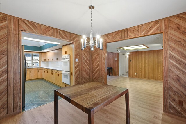 921 Sleepy Hollow Dr, Garland, TX 75043 - unfurnished dining area with a chandelier, wood walls, and wood finished floors