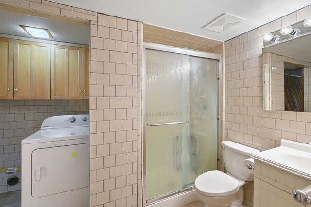 921 Sleepy Hollow Dr, Garland, TX 75043 - bathroom featuring tile walls, washer / dryer, vanity, and a stall shower