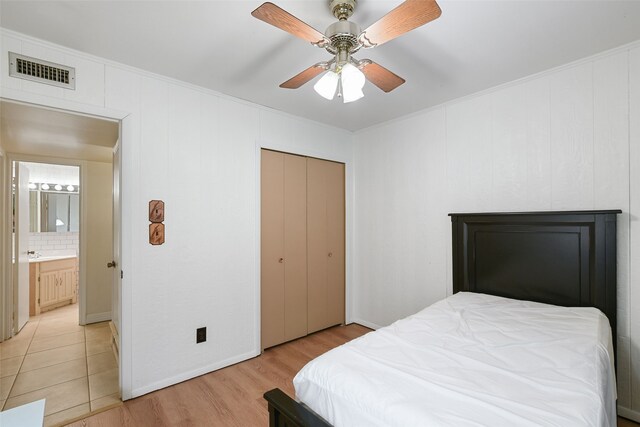 921 Sleepy Hollow Dr, Garland, TX 75043 - bedroom featuring light wood-style flooring, crown molding, ceiling fan, and a closet