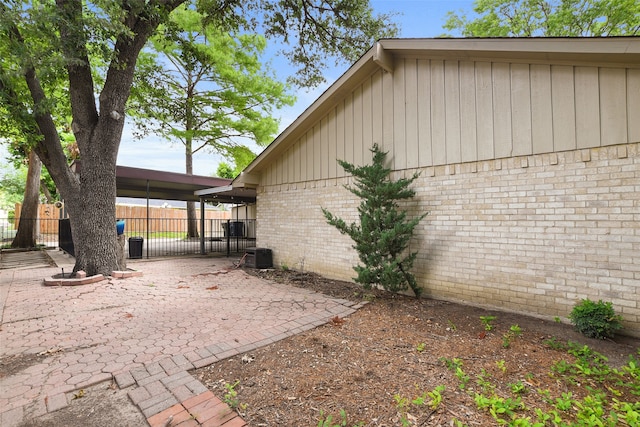 921 Sleepy Hollow Dr, Garland, TX 75043 - view of side of home featuring brick siding, board and batten siding, and a gate