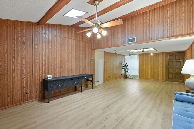921 Sleepy Hollow Dr, Garland, TX 75043 - interior space with beam ceiling, wooden walls, light wood-style floors, and a ceiling fan