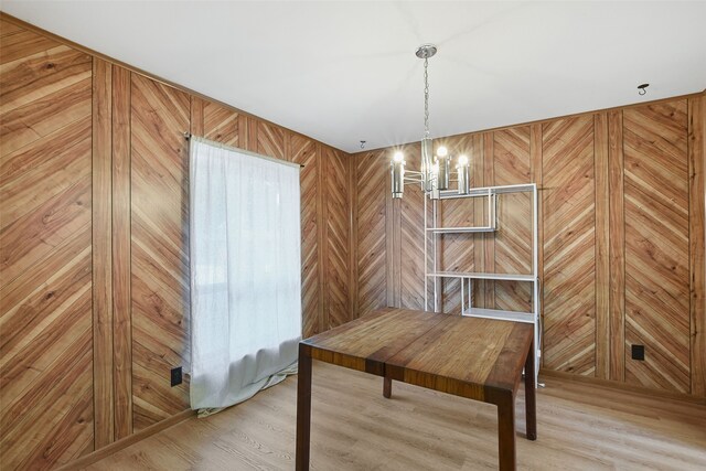 921 Sleepy Hollow Dr, Garland, TX 75043 - unfurnished dining area with a chandelier, light wood-style floors, and wooden walls