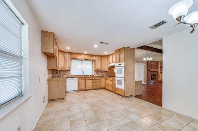 6221 Onyx Dr N, North Richland Hills, TX 76180 - kitchen with white appliances, light tile patterned floors, decorative backsplash, a chandelier, and light brown cabinetry