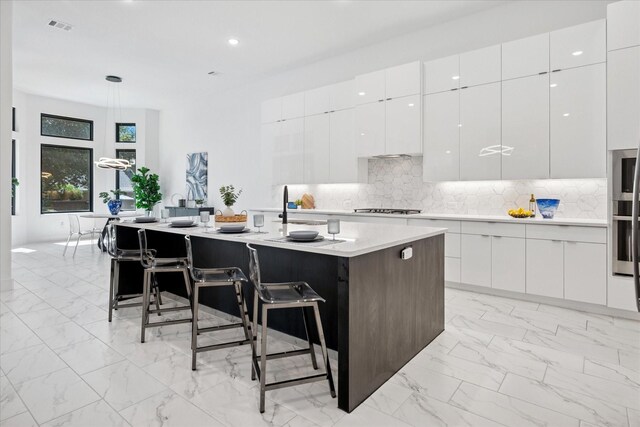 8305 Caballo Dr, North Richland Hills, TX 76182 - kitchen featuring modern cabinets, light marble finish floors, a kitchen bar, white cabinetry, and recessed lighting