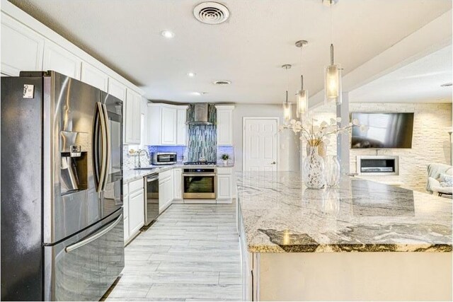 1037 Cavender Dr, Hurst, TX 76053 - kitchen with stainless steel appliances, wall chimney range hood, open floor plan, decorative backsplash, and white cabinets