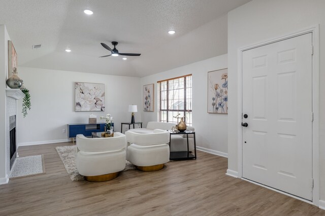 2508 Independence Dr, Mesquite, TX 75150 - living area featuring ceiling fan, light wood finished floors, recessed lighting, a fireplace, and a textured ceiling