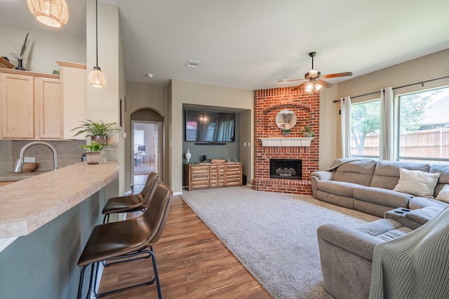 134 Fox Hollow Blvd, Forney, TX 75126 - living room with ceiling fan, wood finished floors, arched walkways, and a fireplace