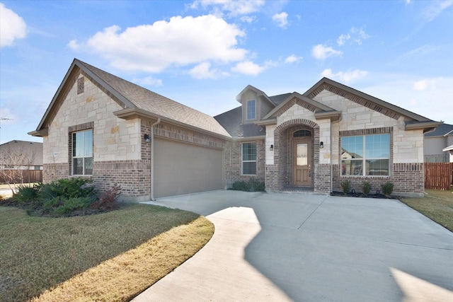 3703 Twin Pines Dr, Grand Prairie, TX 76065 - french country inspired facade featuring stone siding, driveway, an attached garage, brick siding, and roof with shingles
