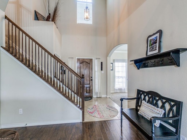 1314 Merrimac Dr, Allen, TX 75002 - entryway featuring arched walkways, stairs, a towering ceiling, and wood finished floors