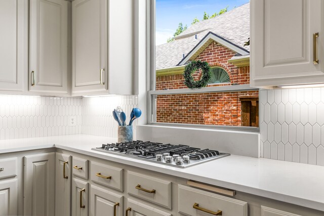 406 Old York Rd, Coppell, TX 75019 - kitchen with stainless steel gas stovetop, backsplash, light countertops, and white cabinetry