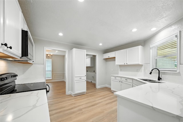 3505 Scott Dr, Rowlett, TX 75088 - kitchen with range with electric cooktop, light stone counters, stainless steel microwave, healthy amount of natural light, and a textured ceiling