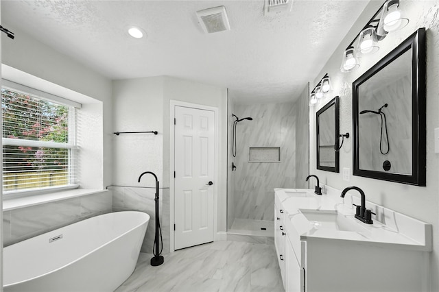 3505 Scott Dr, Rowlett, TX 75088 - bathroom with a soaking tub, a stall shower, double vanity, marble finish flooring, and a textured ceiling