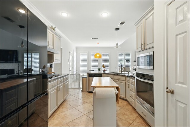 1604 Tree Line Rd, Flower Mound, TX 75028 - kitchen with appliances with stainless steel finishes, a peninsula, decorative light fixtures, a center island, and butcher block counters