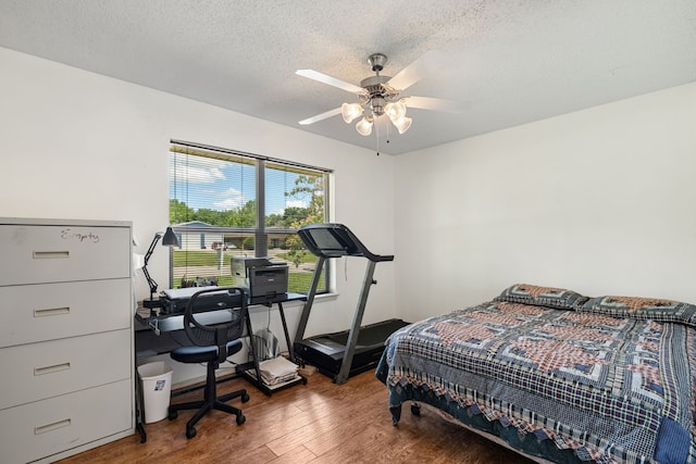 1309 N Mill St, Bowie, TX 76230 - bedroom with wood finished floors, a textured ceiling, and ceiling fan