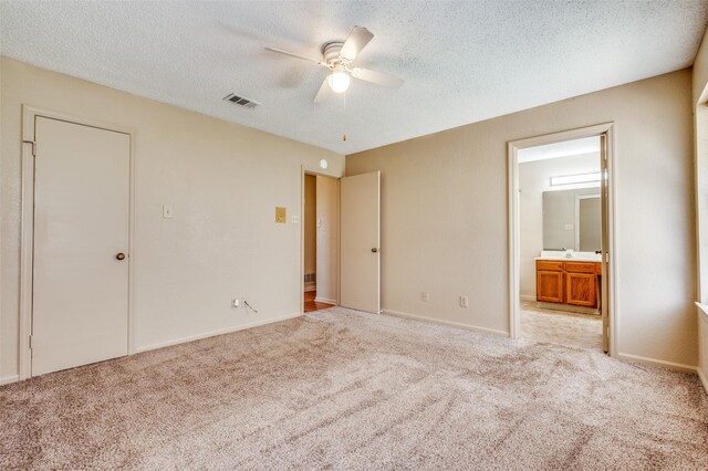 304 Mack Dr, Denton, TX 76209 - unfurnished bedroom with light colored carpet, a textured ceiling, connected bathroom, and a ceiling fan