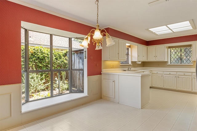 10009 Apple Creek Dr, Dallas, TX 75243 - kitchen with wainscoting, light countertops, a peninsula, pendant lighting, and ornamental molding