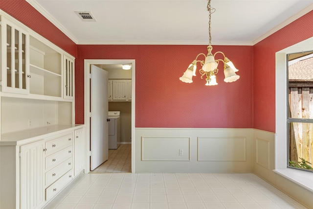10009 Apple Creek Dr, Dallas, TX 75243 - unfurnished dining area with washer / dryer, a chandelier, ornamental molding, a wainscoted wall, and a decorative wall