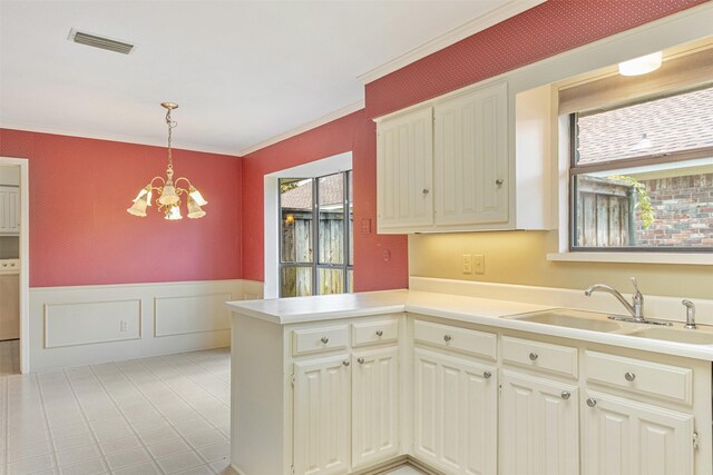 10009 Apple Creek Dr, Dallas, TX 75243 - kitchen with a chandelier, a wainscoted wall, a peninsula, ornamental molding, and hanging light fixtures