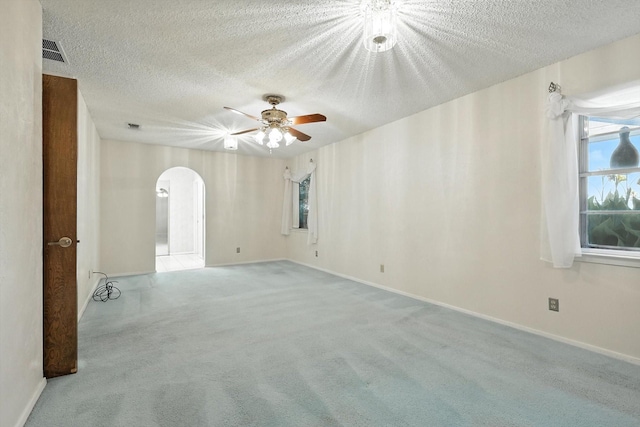 233 Hillview Dr, Hurst, TX 76054 - unfurnished room with arched walkways, a textured ceiling, ceiling fan, and carpet floors