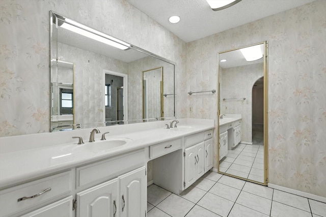 233 Hillview Dr, Hurst, TX 76054 - full bathroom with double vanity, tile patterned floors, wallpapered walls, and a textured ceiling