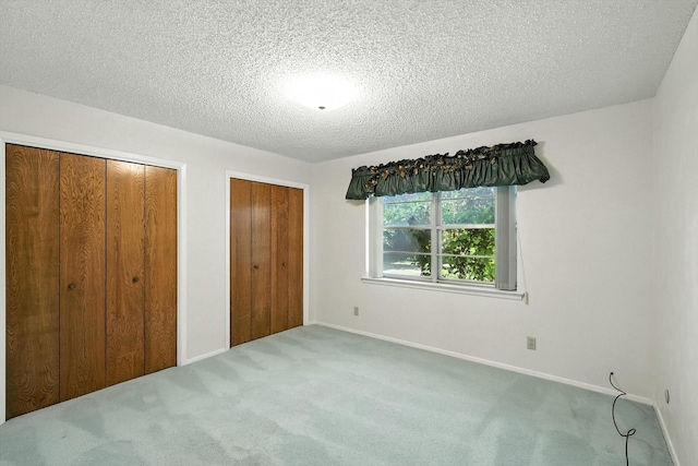 233 Hillview Dr, Hurst, TX 76054 - unfurnished bedroom with two closets, carpet, and a textured ceiling